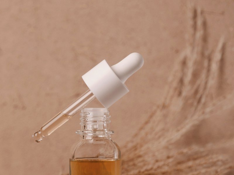 Serumflesje met pipet voor een beige achtergrond met pampas