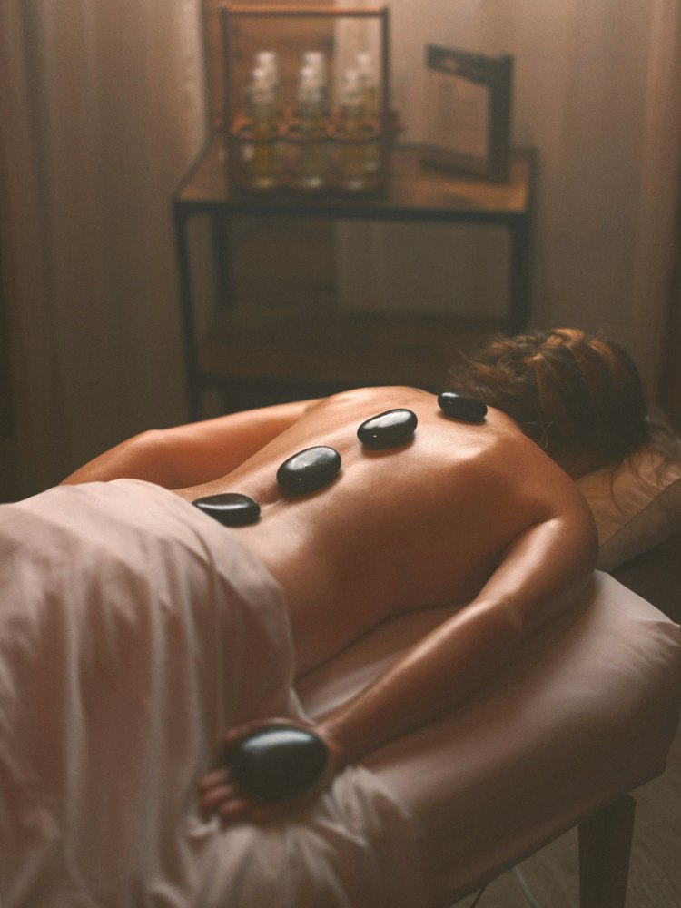 Hotstone-massage met warme stenen op de rug